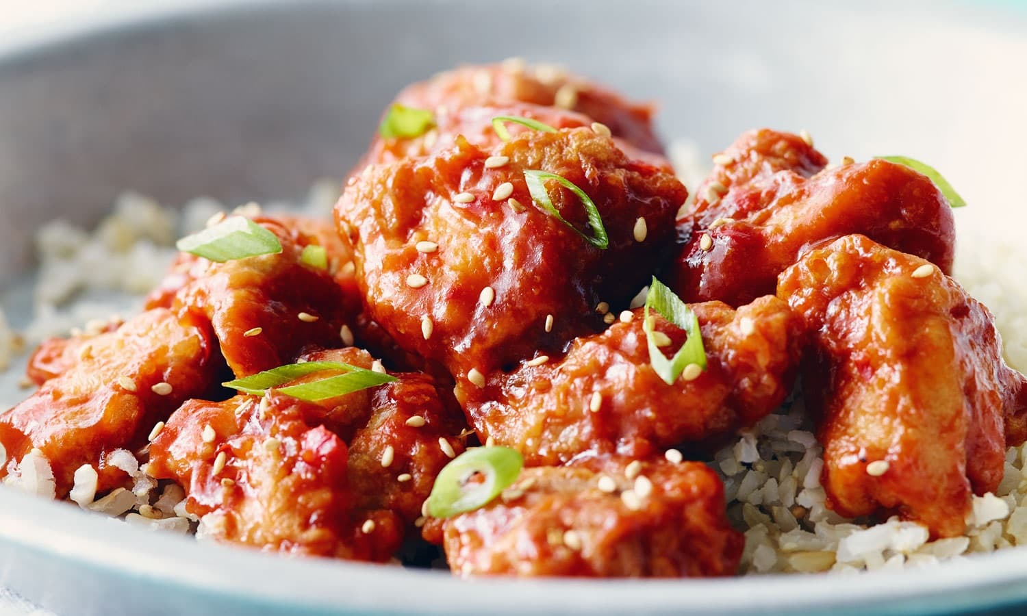 Poulet général Tao de La Citronnelle : morceaux laqués garnis de sésame et d'oignons verts, servis sur riz